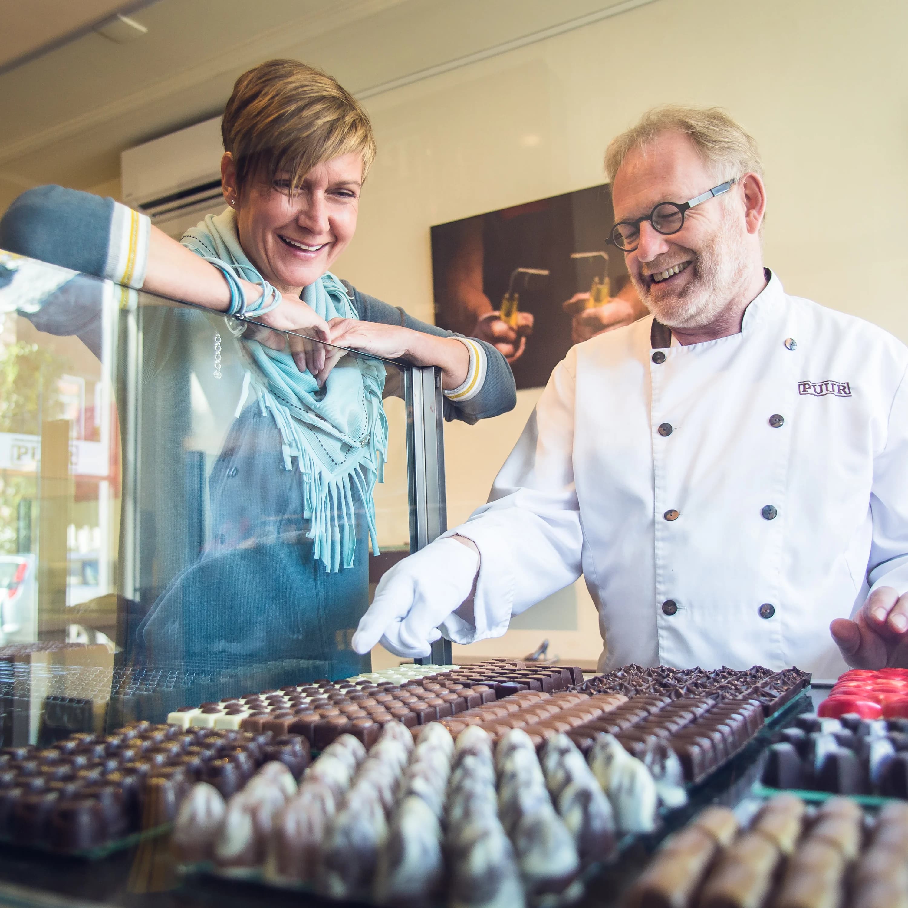 Personal branding fotografie van een ondernemer samen met een chocolatier in zijn winkel